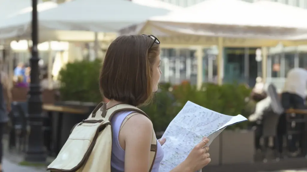 Solo traveler reading a city map with a backpack